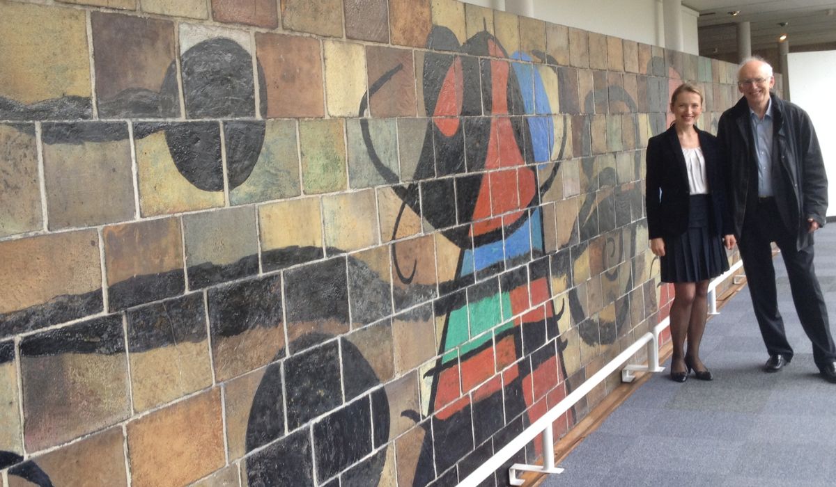 Irena and her Cambridge supervisor Christopher Hill in front of the Joan Miró mural at UNESCO Headquarters during his visit to Paris in 2015