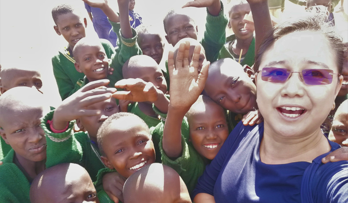 Maria Baylon with school children in Tanzania.