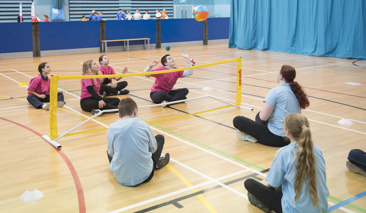 Studnts playing sitting down volleyball