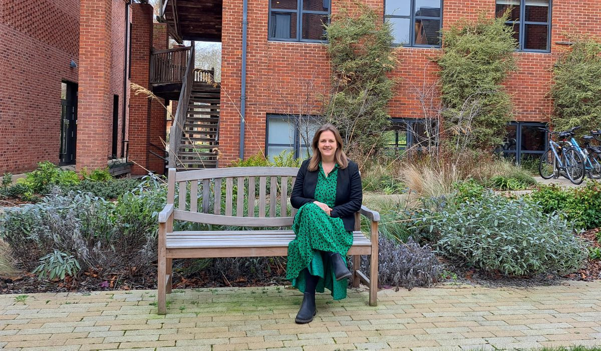 Annna Smith sitting on a bench in Lucy Cavendish's courtyard