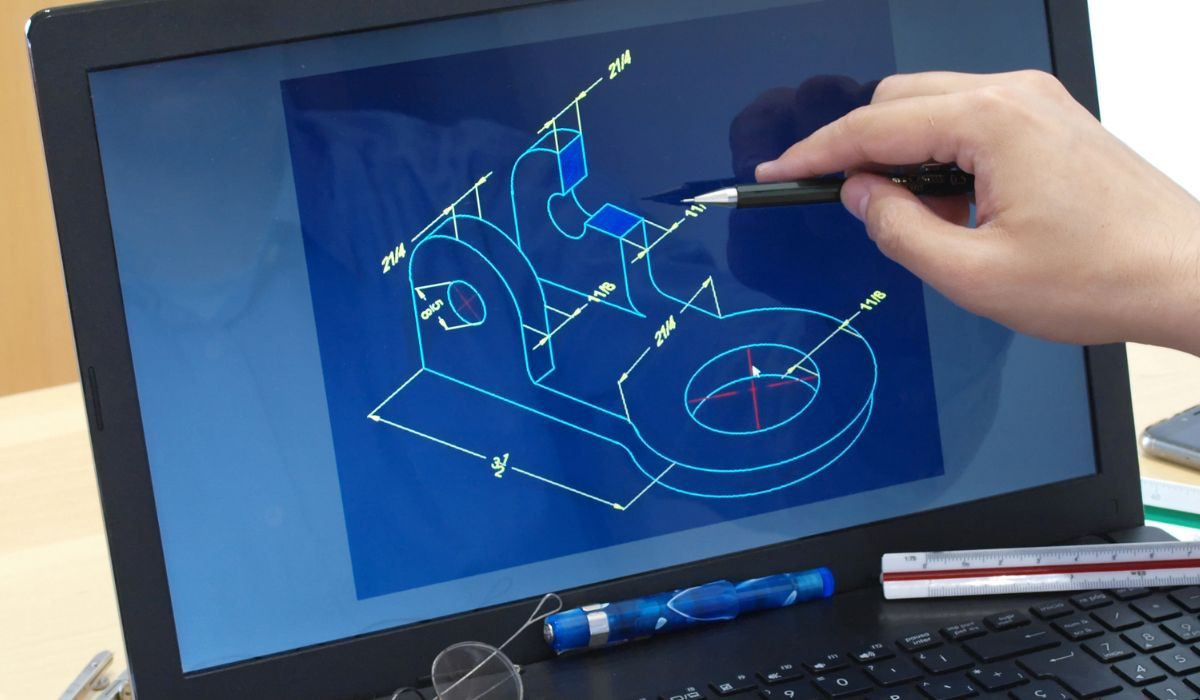 The image shows a close-up of a person's hand using a laptop computer and a pen to create a digital drawing. 