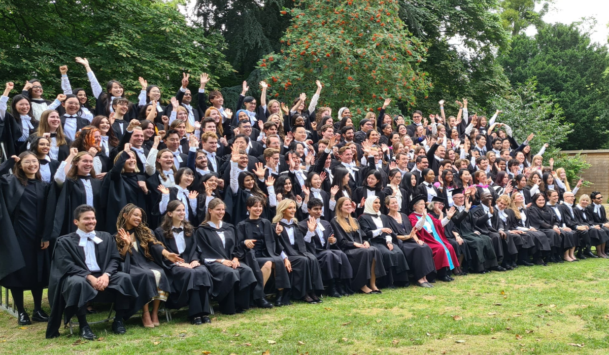 Postgraduate students in group celebrating with their hands in the air