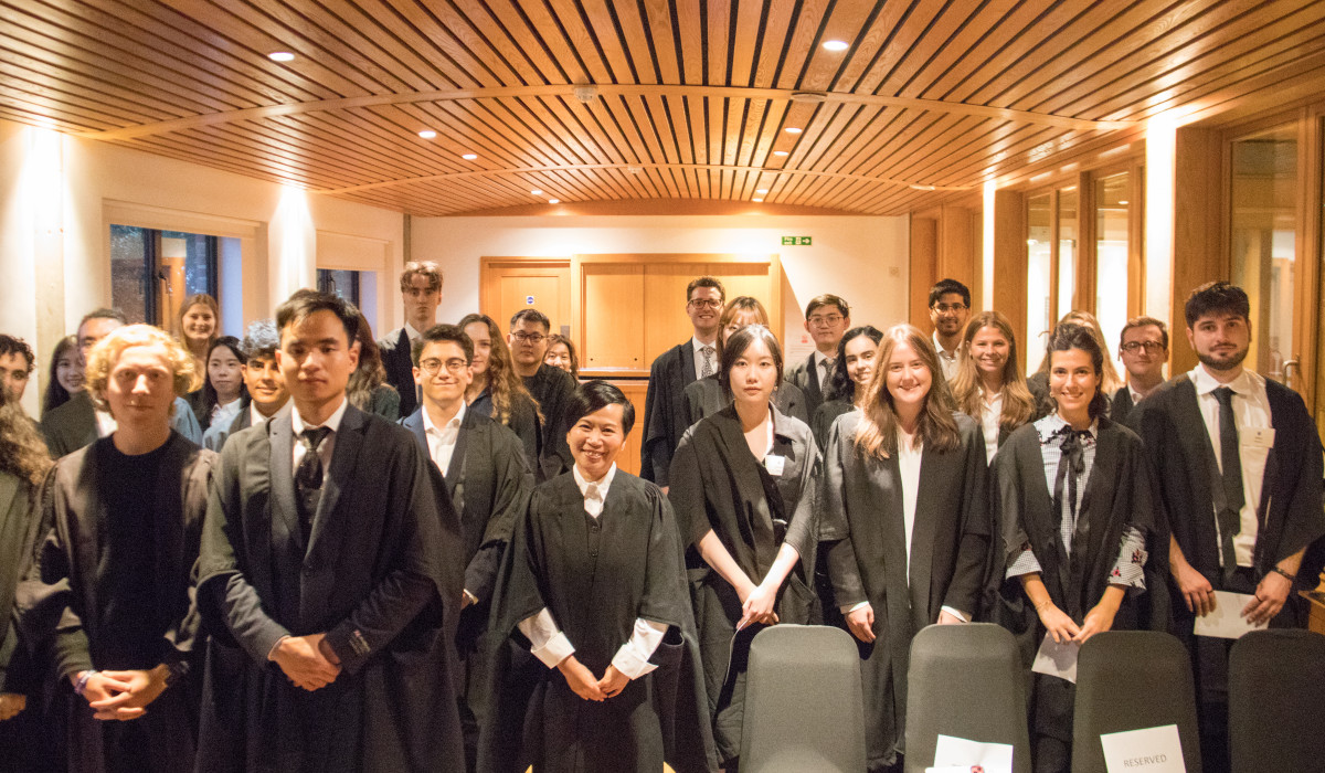 Ms Shirley Chong and masters students in matriculation gowns in the reception rooms at the College