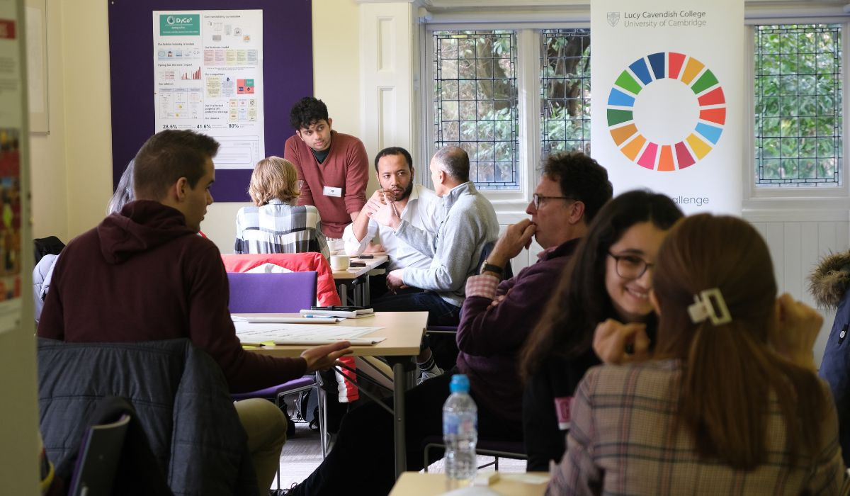 Students and mentors sitting at tables in the WoodLegh room