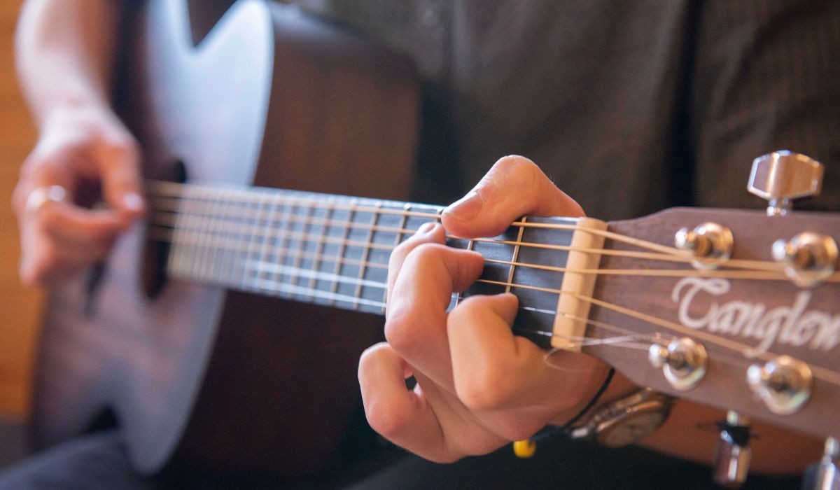 Close-up of person's hands playing guitar