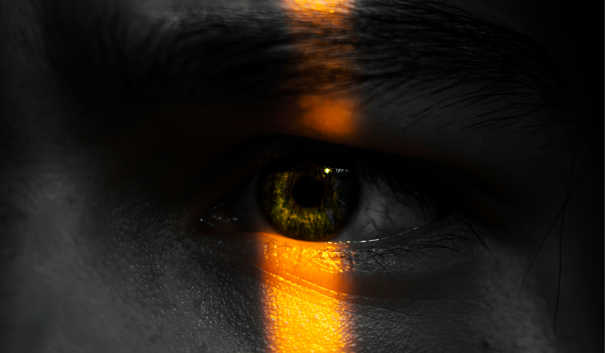 Close up of person's face with eye illuminated by strip of light 