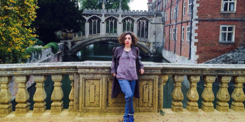 Zoe Angeli standing on St Johns College bridge with Bridge of Sighs in the background
