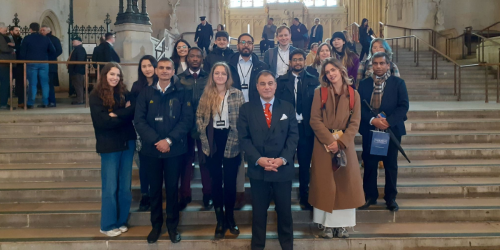Lucy students and Lord Bilimoria standing on steps at UK Parliament